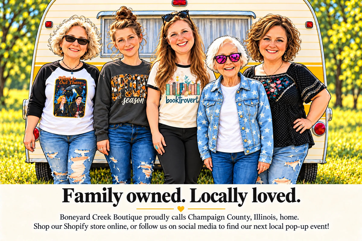 The Boneyard Creek Boutique family in front of a vintage camper. Family owned. Locally loved. Boneyard Creek Boutique proudly calls Champaign County, Illinois, home.