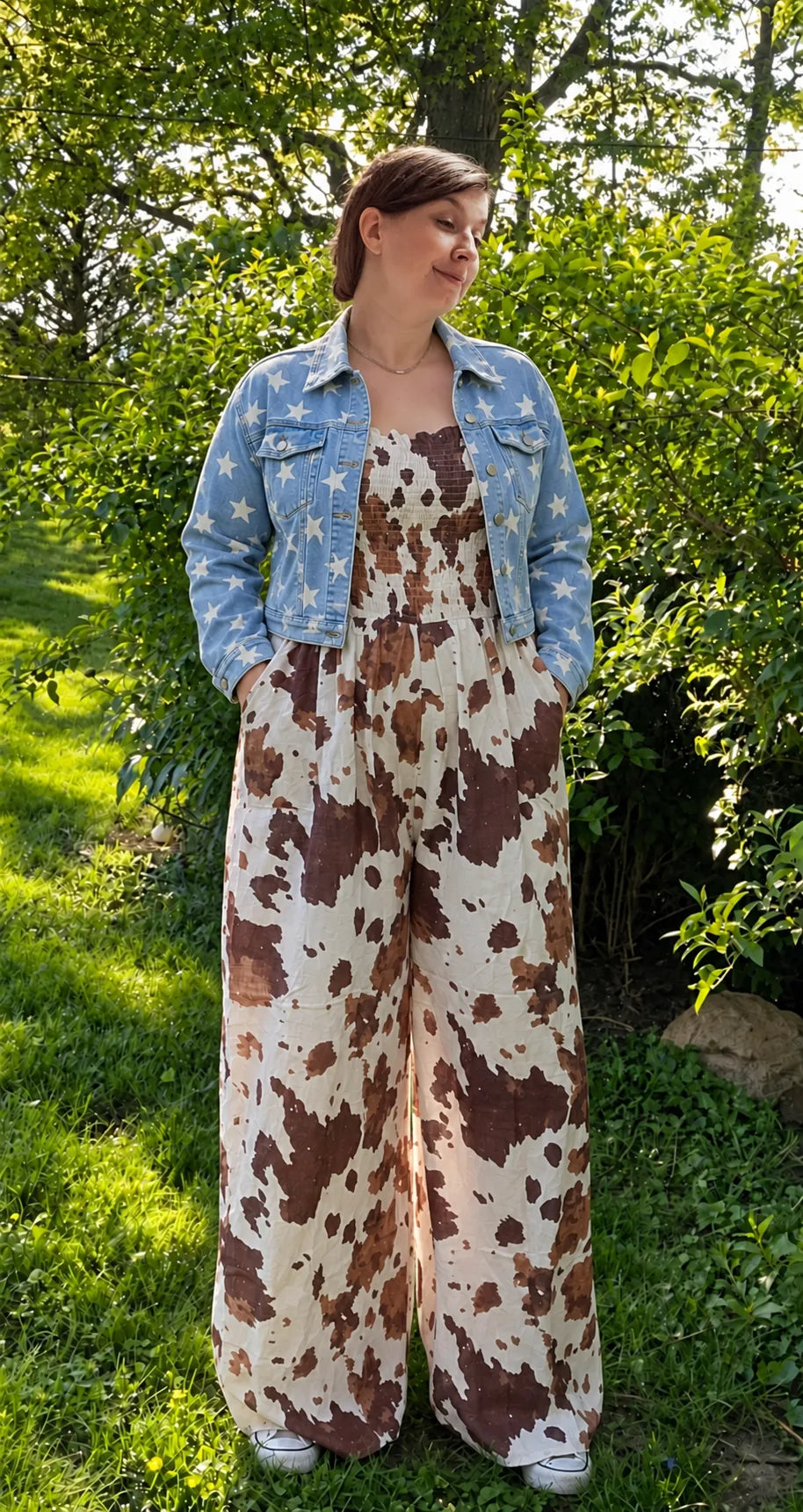 Model wearing the Cow Camo Smocked Wide Leg Jumpsuit with a star print denim jacket